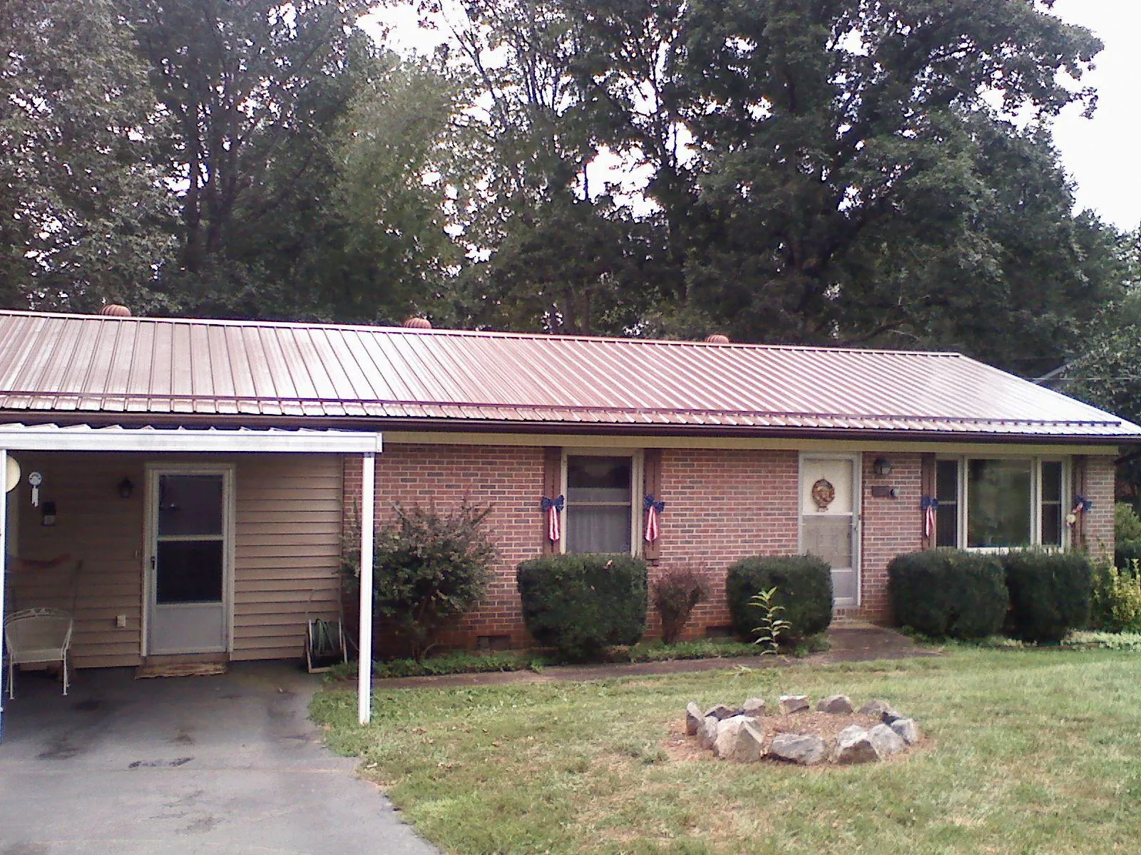Bronze metal roof and carport on a brick ranch home — Roof Repair work by our crew in Slatersville