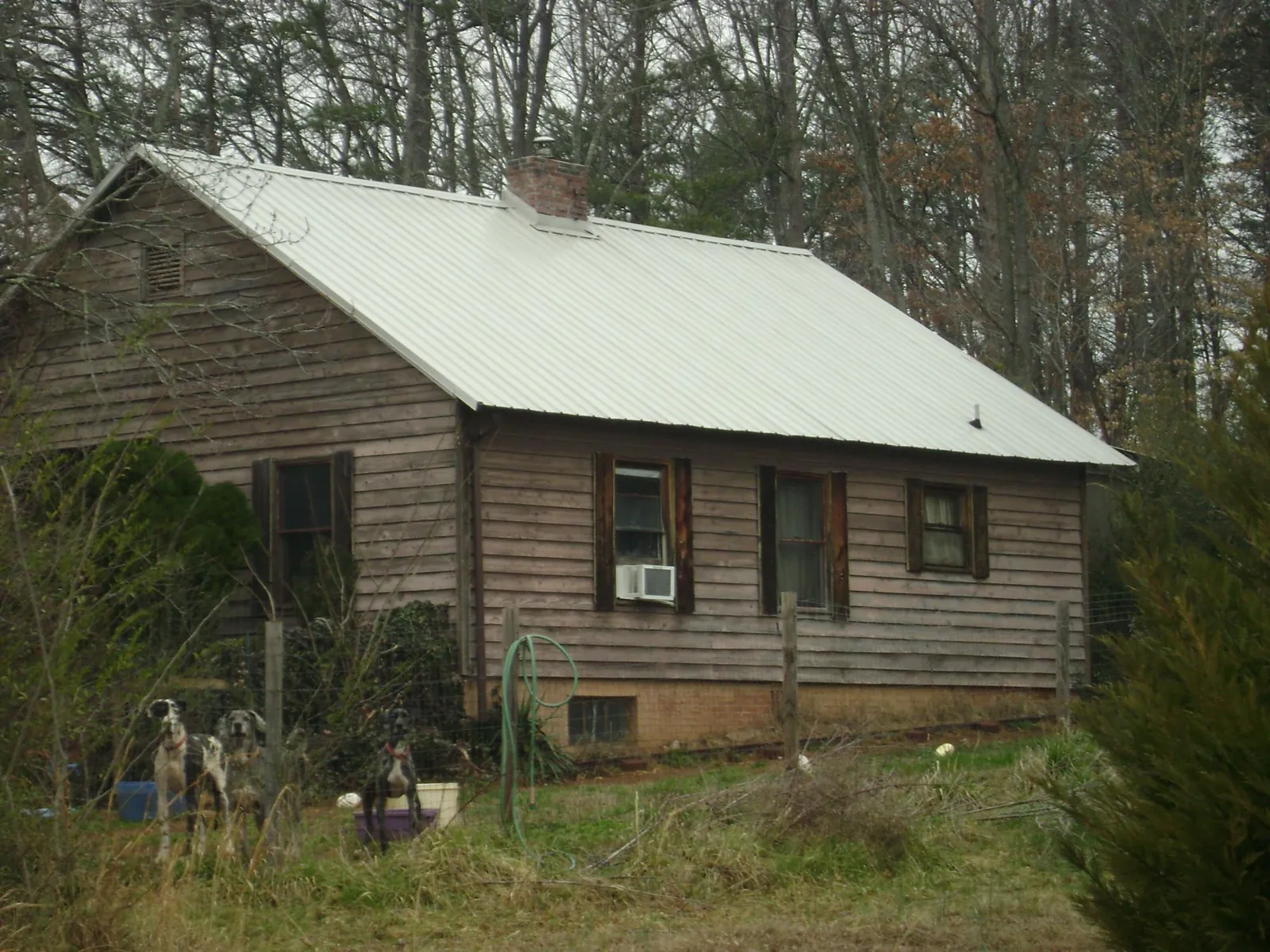 White metal roof on an old wood sided farmhouse, from a Metal Roof Installation job in Slatersville